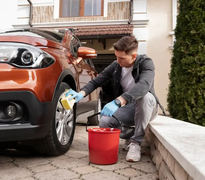 Lavage auto à domicile Ambrault : professionnel intervenant sur un véhicule